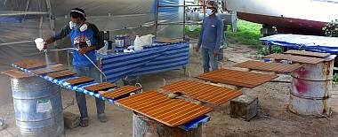 Baw & Heru spraying polyurethane on some of our floorboards