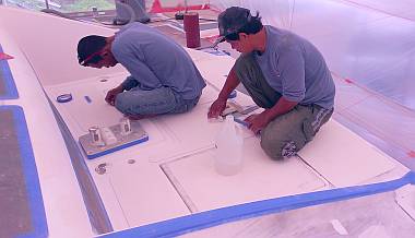 Baw and Pla finalizing gelcoat preparations on the foredeck