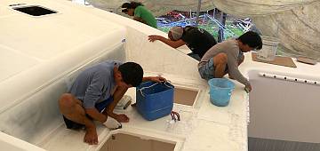 Wet-sanding the foredeck with ever finer grits of paper