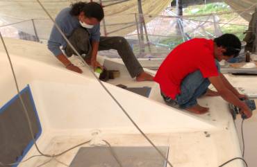 Jack & Baw smoothing Ocelot's foredeck for gelcoat