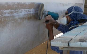 Jack sanding off the damaged epoxy filler from the waterline