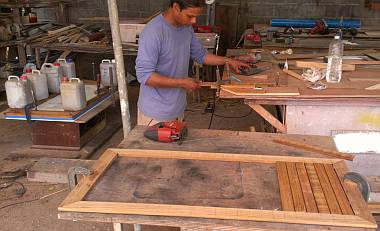 Frame being set onto a hatch on left, trimming teak slats in front