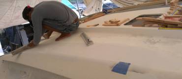 Heru smoothing off the new filler on the starboard cabin-top