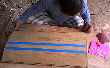 Houa gluing in one of the vertical teak frames on a rounded door