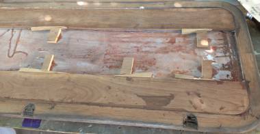 2 strips of teak, held by wedges, being epoxied into the table