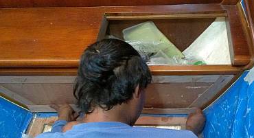 Houa making a template of the teak veneer he has to replace