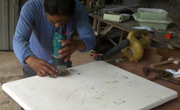 Houa cutting a hole in the chain-locker hatch for the handle