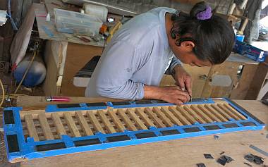 Houa gluing rubber pads to the bottom of the teak grate