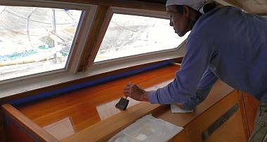 Lek brushing thinned epoxy on the big salon teak shelves